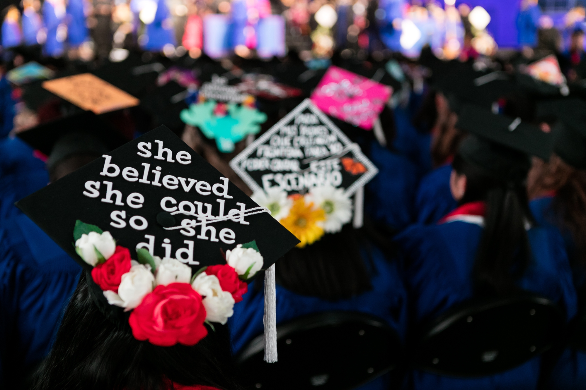 Students show off their decorated mortar boards during the commencement ceremony for the College of Science and Health  and the College of Education at Chicago's Wintrust Arena. (DePaul University/Jeff Carrion)